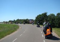 De deelnemers van Flipje op wielen passeren hier de kerk en even later het kasteel in Echteld tijdens een toertocht naar Ochten