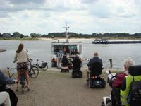 De deelnemers van Flipje op wielen rijden de veerpont Pomona op voor een overtocht naar Maas en Waal