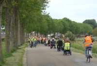 Tijdens de toertocht kruist de fietsclub uit Beesd de deelnemers van Flipje op wielen. Een spontaan moment met hartelijke begroetingen.